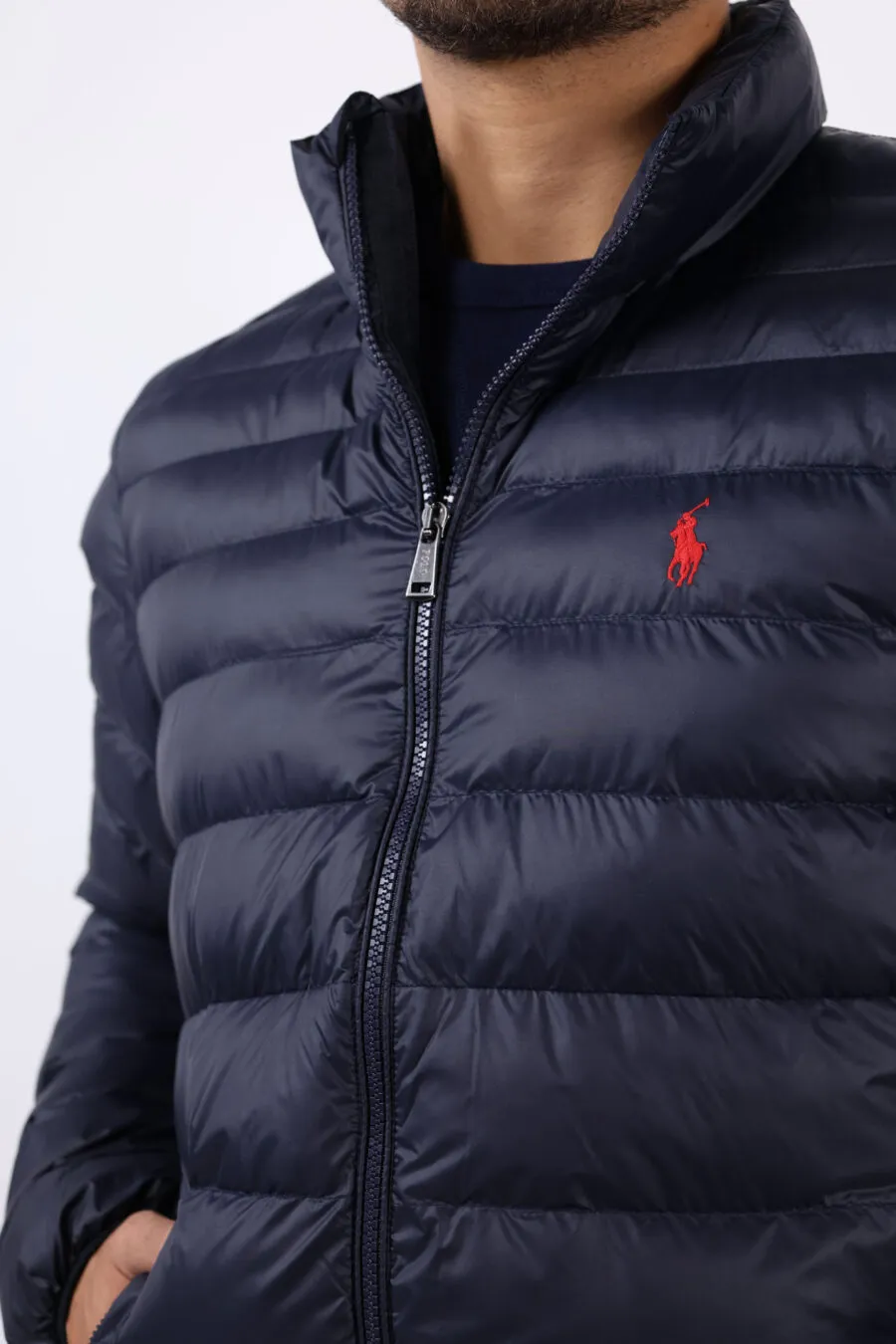 Chaqueta plumífero azul con logo rojo